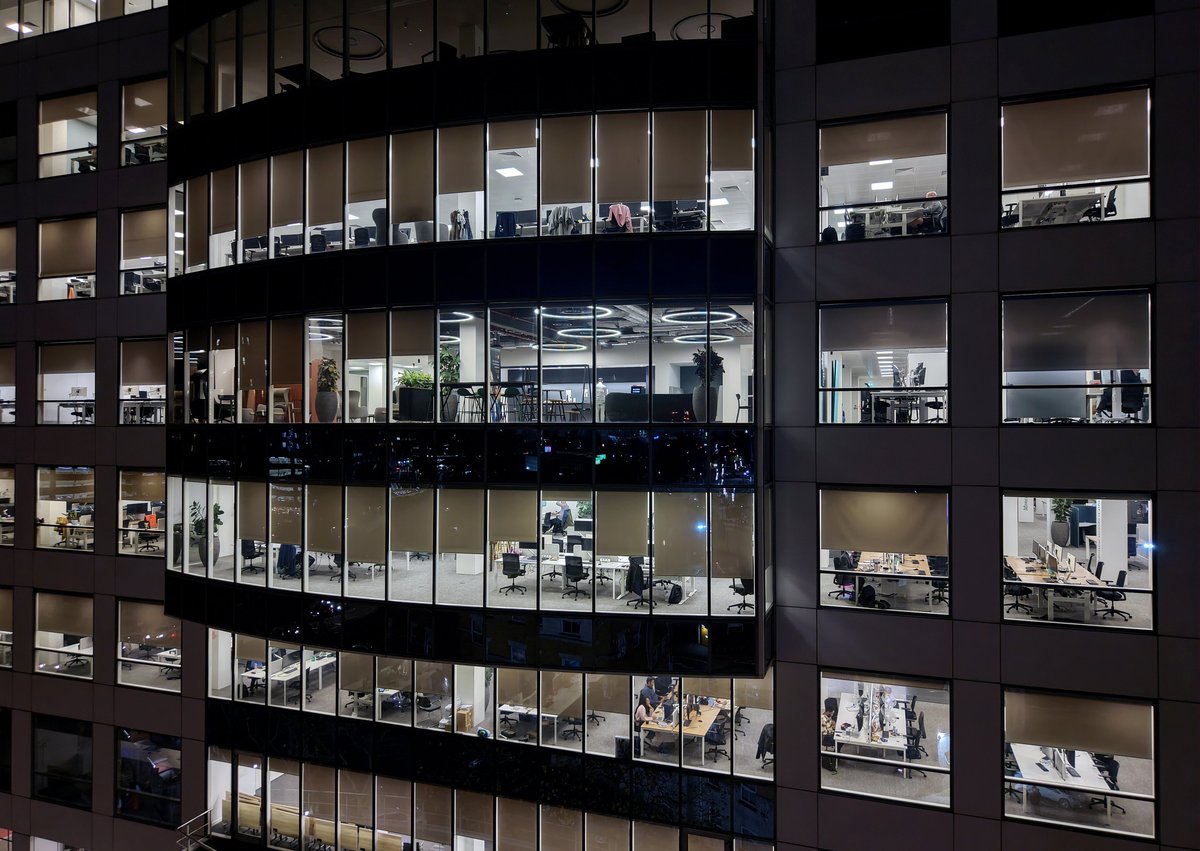 Glass facade of a modern corporate building illuminated at night